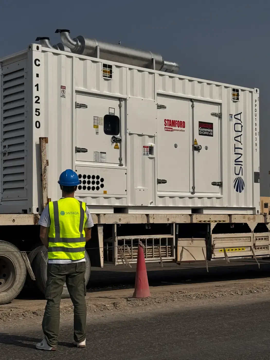SINTAQA engineer next to a containerised generator on site