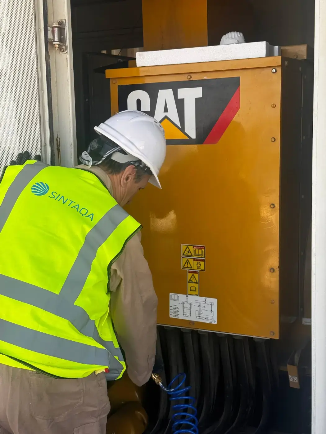 SINTAQA field engineer servicing a generator for an oil and gas site